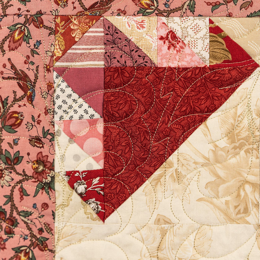 Close-up of a patchwork quilt with floral and geometric patterns