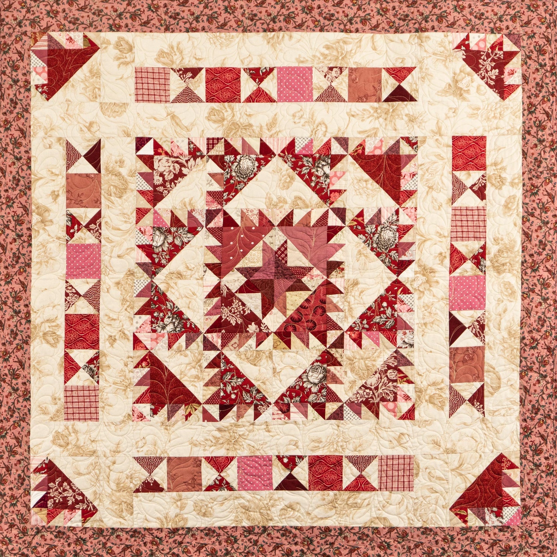 Quilt with red and beige geometric pattern on a matching border