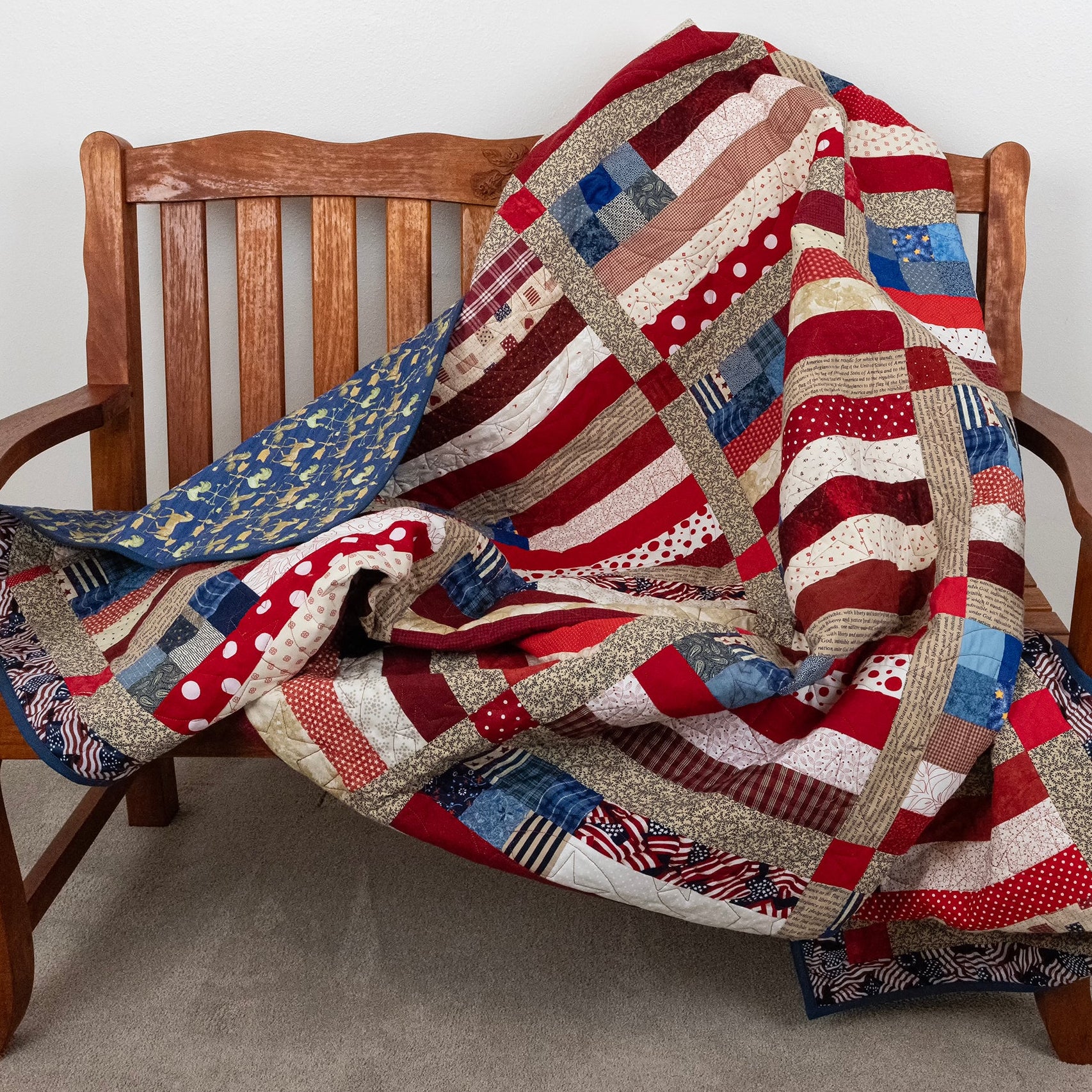 Colorful patchwork quilt draped over a wooden chair against a plain background