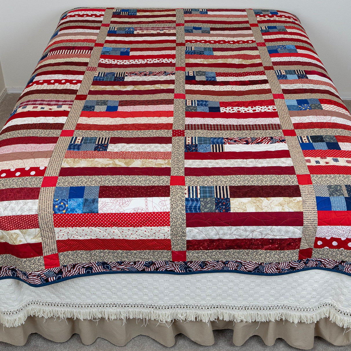 Patchwork quilt with red, white, and blue pattern on a bed