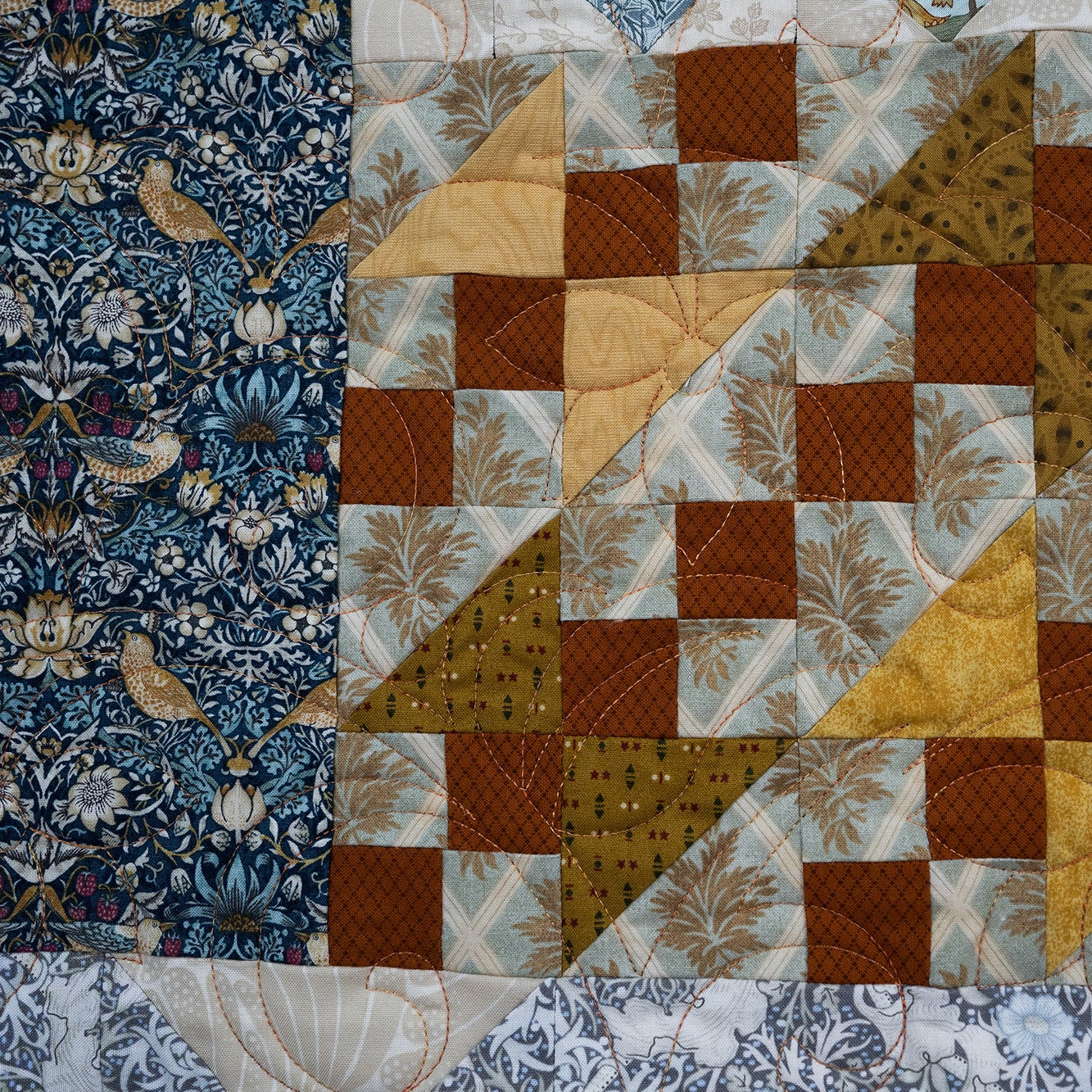Quilt with a patchwork design featuring various patterns and colors.
