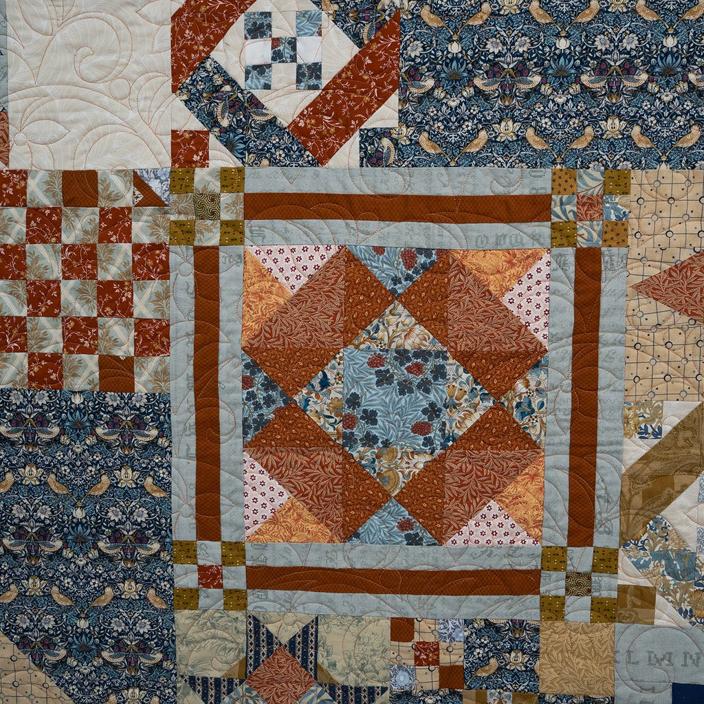 Patchwork quilt with various geometric and floral patterns in earthy tones.