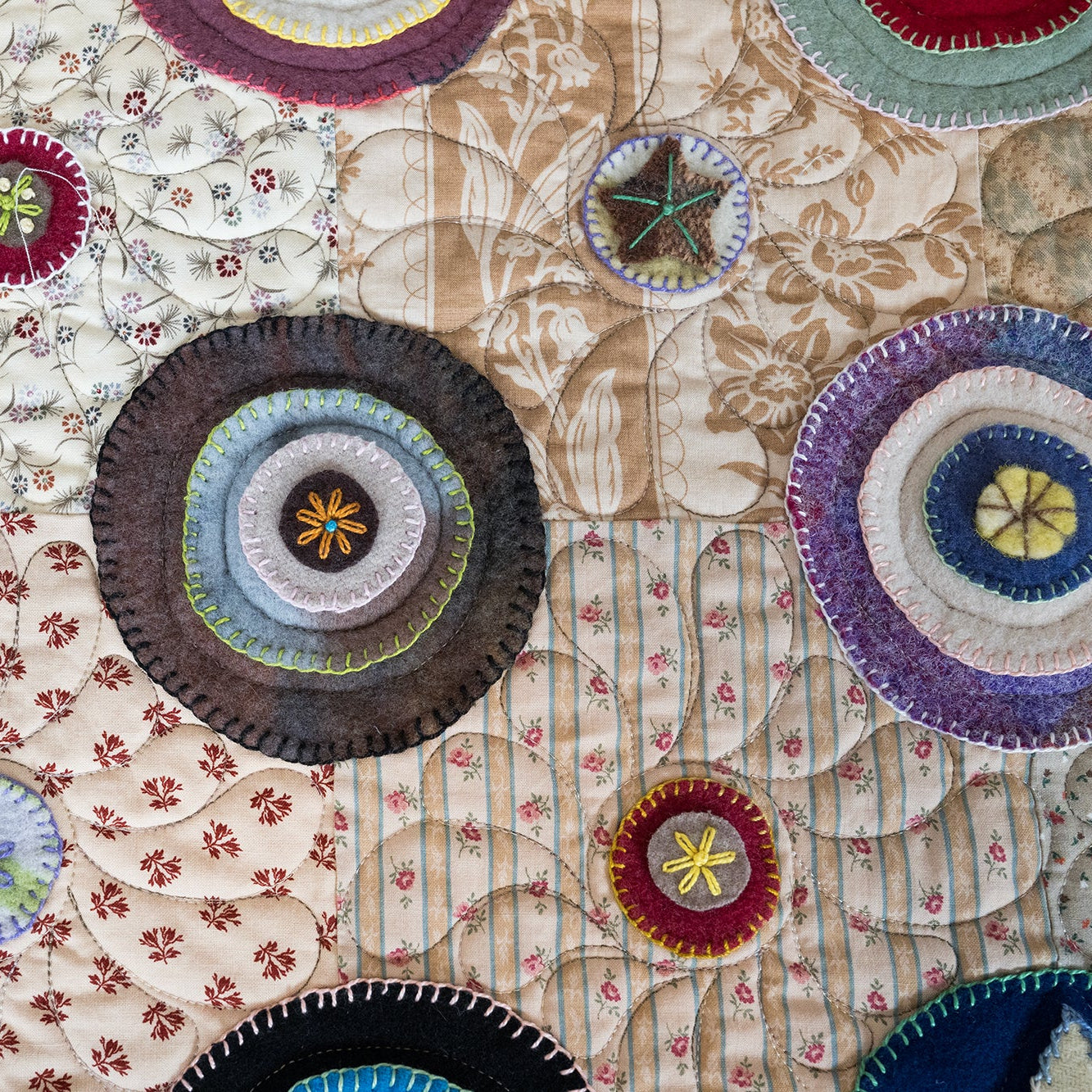 Close-up of a quilt with circular patchwork designs on a floral background