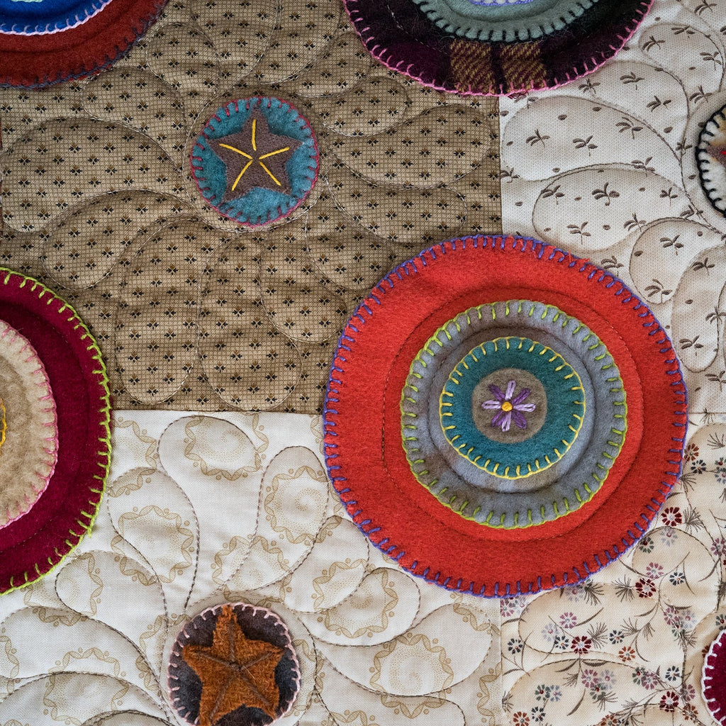 Close-up of colorful circular patterns on a textured fabric background