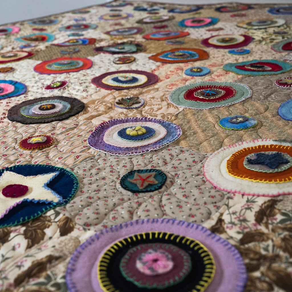 Colorful patchwork quilt with circular patterns on a floral background