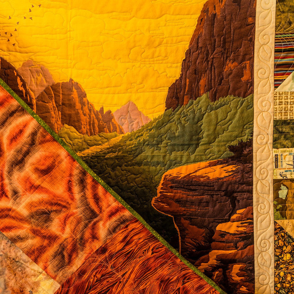 Quilt with a landscape design featuring mountains and valleys.