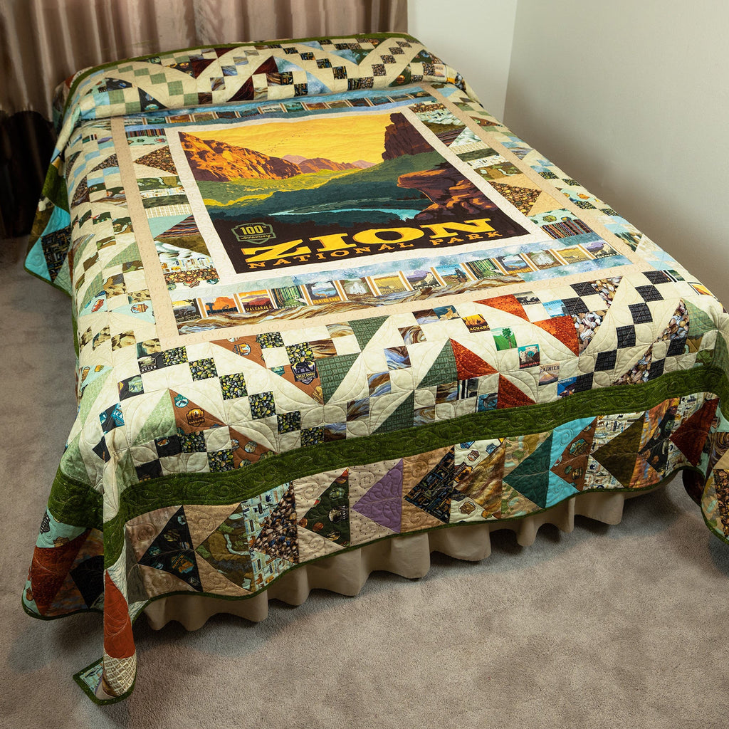 Colorful quilt with scenic design on a bed in a room.