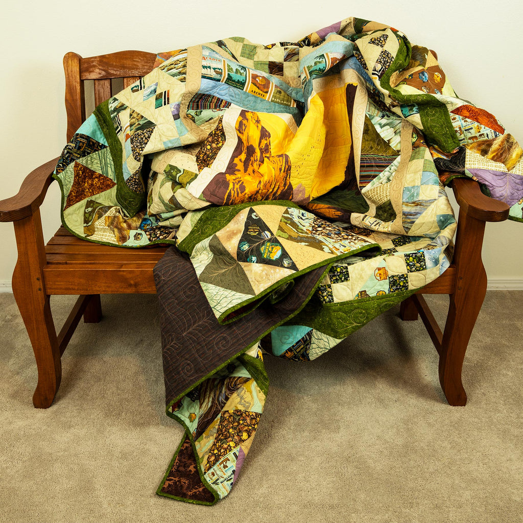 Colorful quilt draped over a wooden chair against a plain wall.